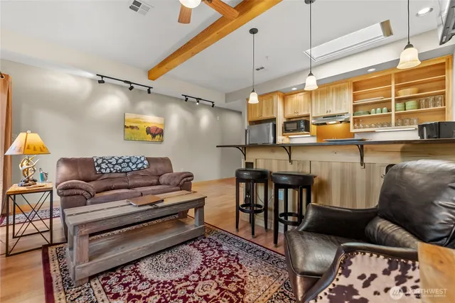 a kitchen with stainless steel appliances granite countertop a stove a sink dishwasher and cabinets with wooden floor