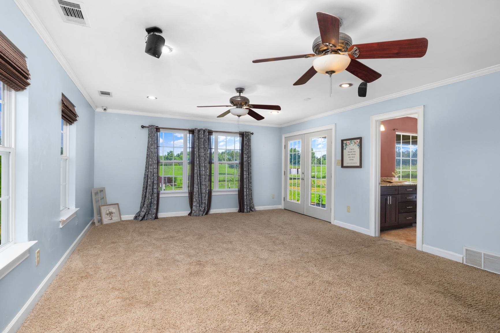 420 Sanford Road Covington, TN 38019 - Photo 11 of 27 Carpeted room with multiple windows, two ceiling fans, recessed lighting, and a double-door entry