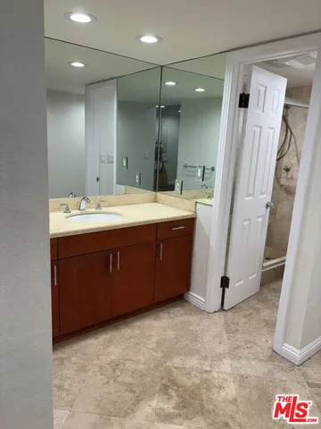 a bathroom with a sink a mirror and a shower