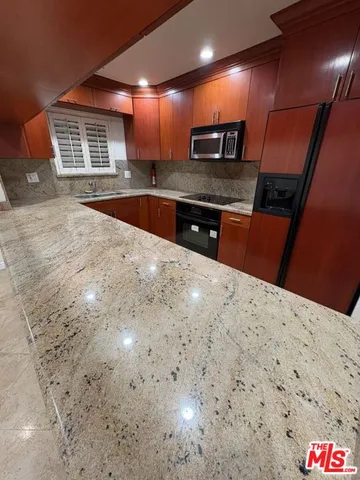 a kitchen with stainless steel appliances a refrigerator and a sink