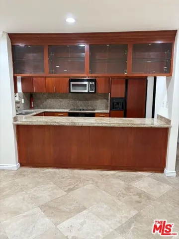 a room with stainless steel appliances wooden cabinets and entryway