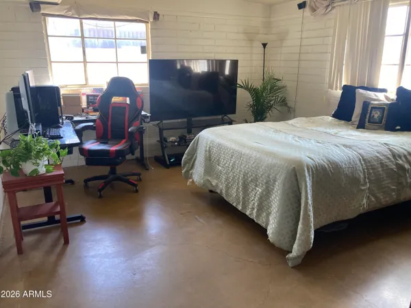 a bedroom with a bed chair and a window