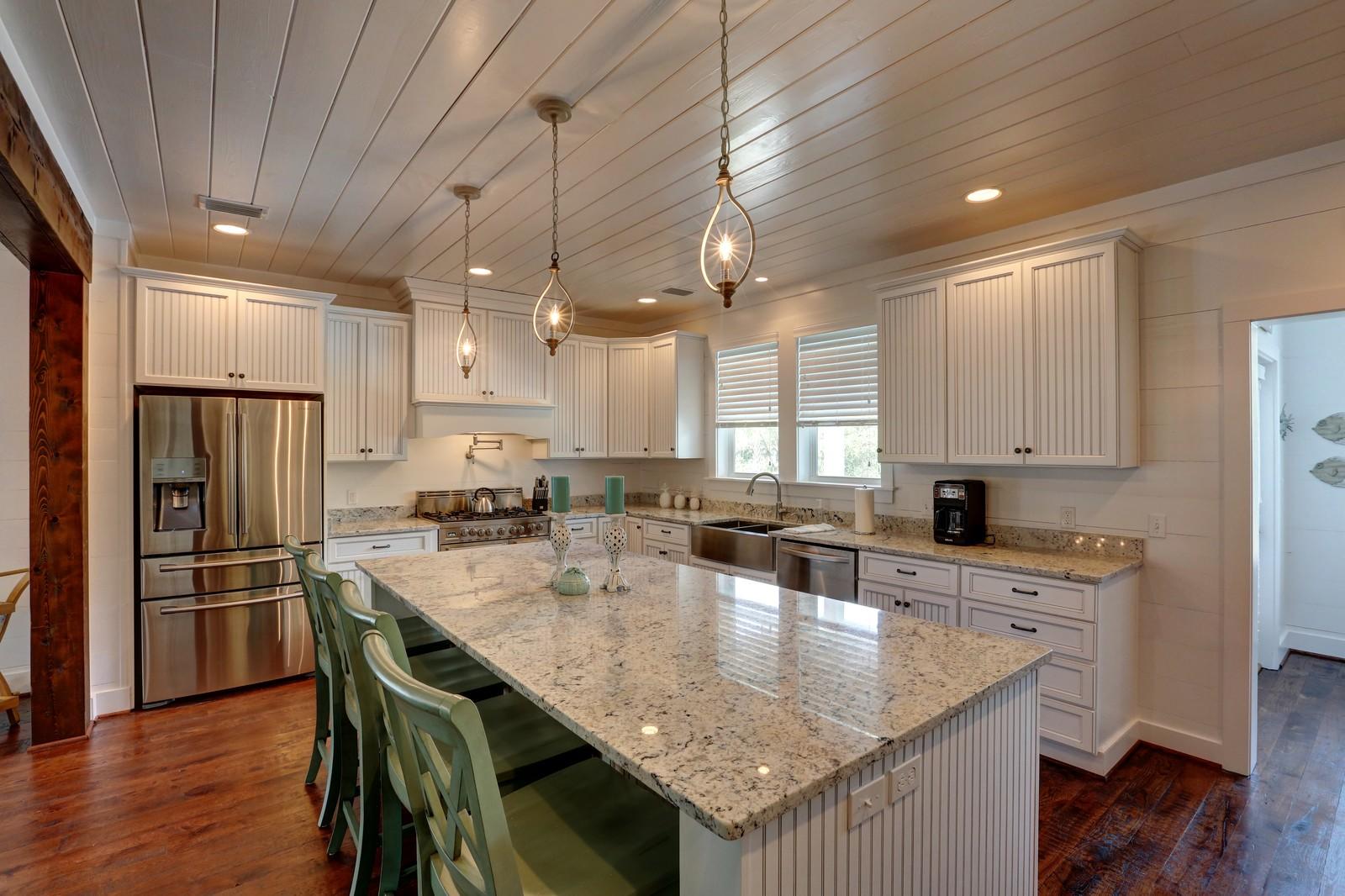 72 Gulf Point Road Santa Rosa Beach, FL 32459 - Photo 15 of 47 a kitchen with a refrigerator a kitchen island and chairs in it