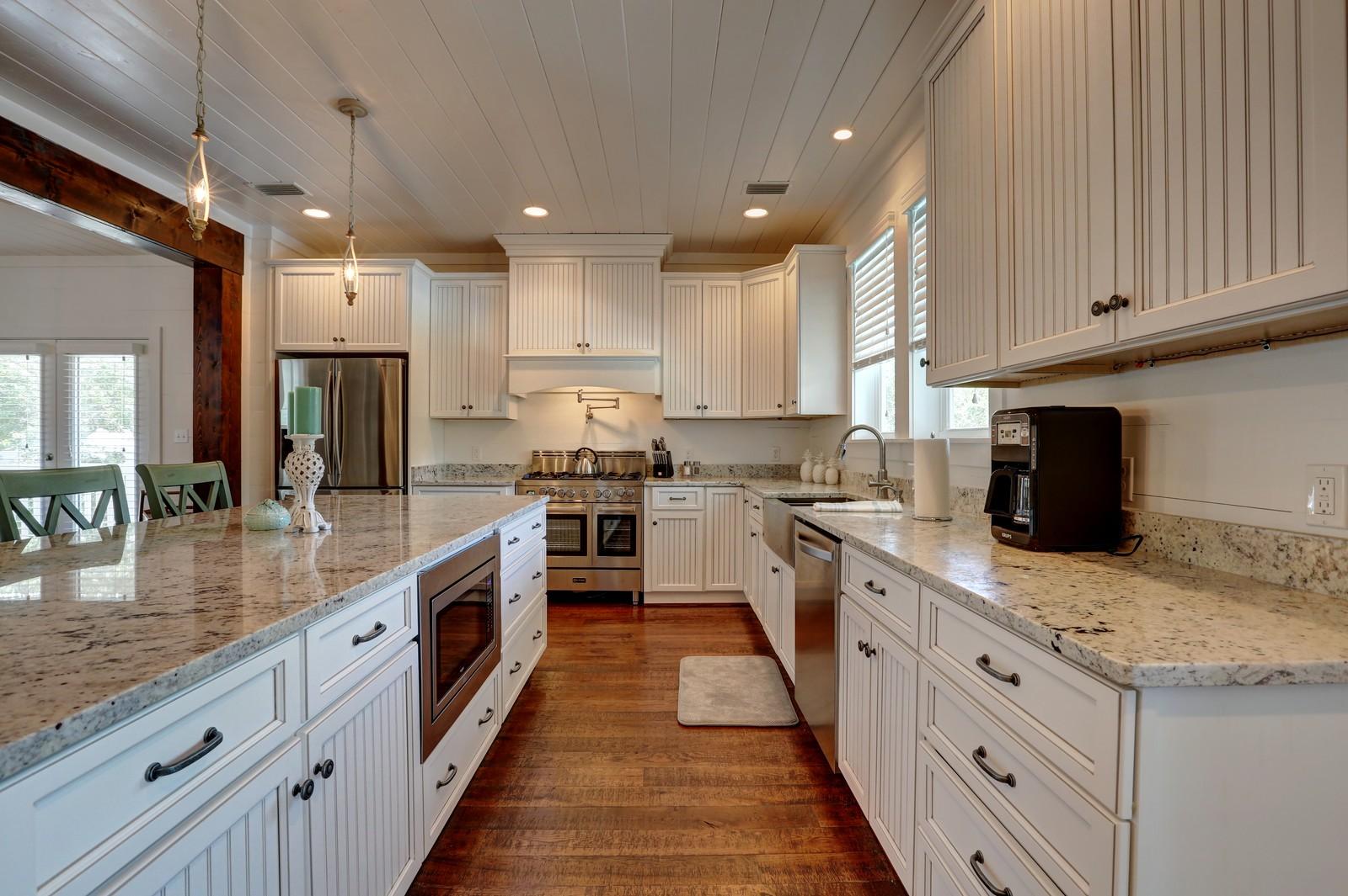 72 Gulf Point Road Santa Rosa Beach, FL 32459 - Photo 16 of 47 a large kitchen with stainless steel appliances granite countertop a stove top oven a sink dishwasher and a refrigerator with wooden cabinets