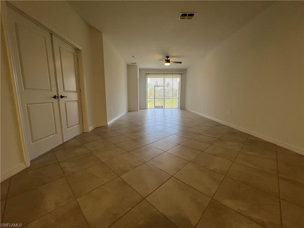 2320 Dragonfruit Way Naples, FL 34120 - Photo 9 of 33 Empty room with light tile patterned flooring, baseboards, a ceiling fan, and visible vents