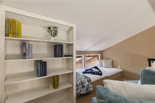 a bedroom with a bed a dresser and wooden floor