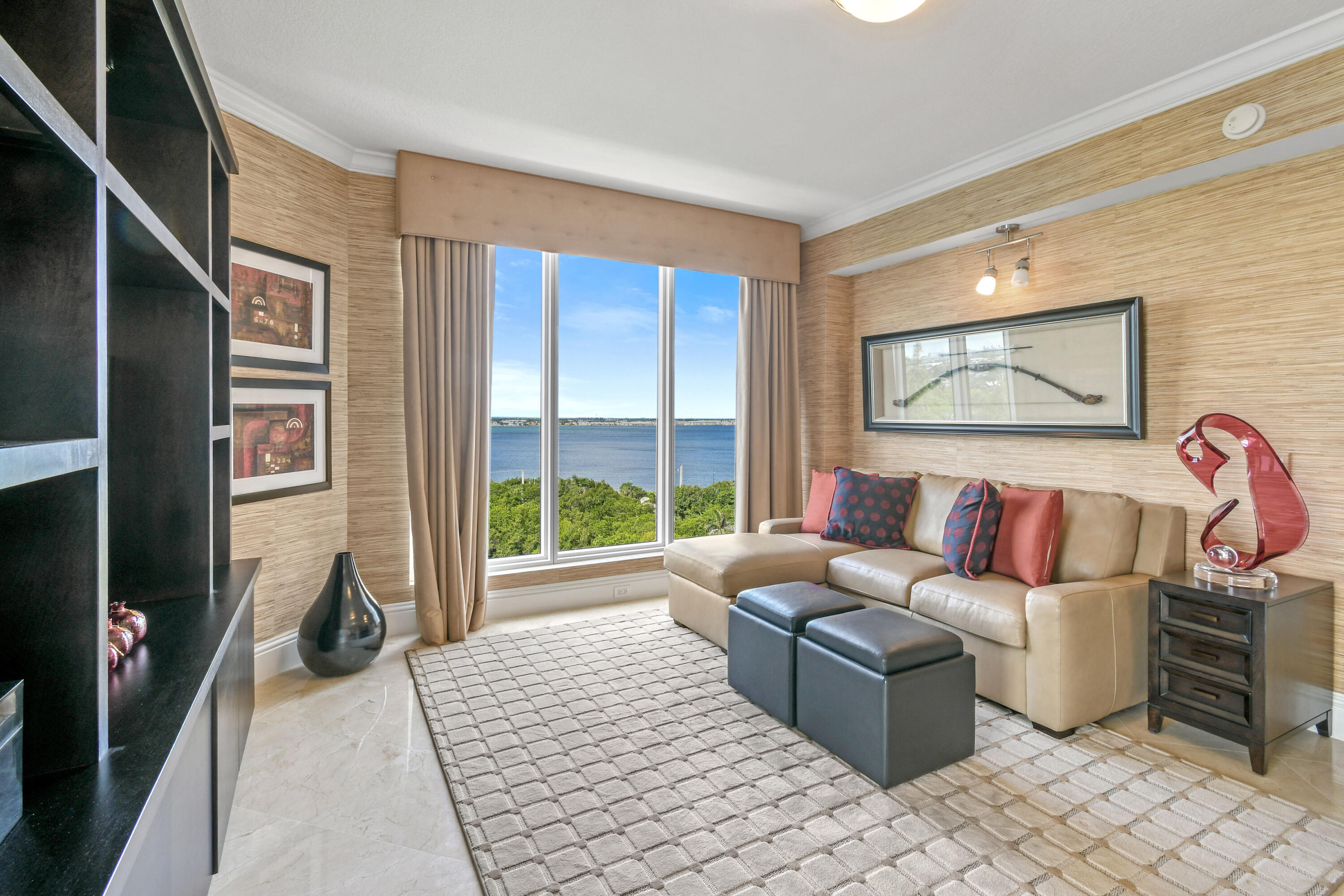 5050 North Ocean Drive, Unit 703 Singer Island, FL 33404 - Photo 19 of 52 a living room with furniture a flat screen tv and a floor to ceiling window