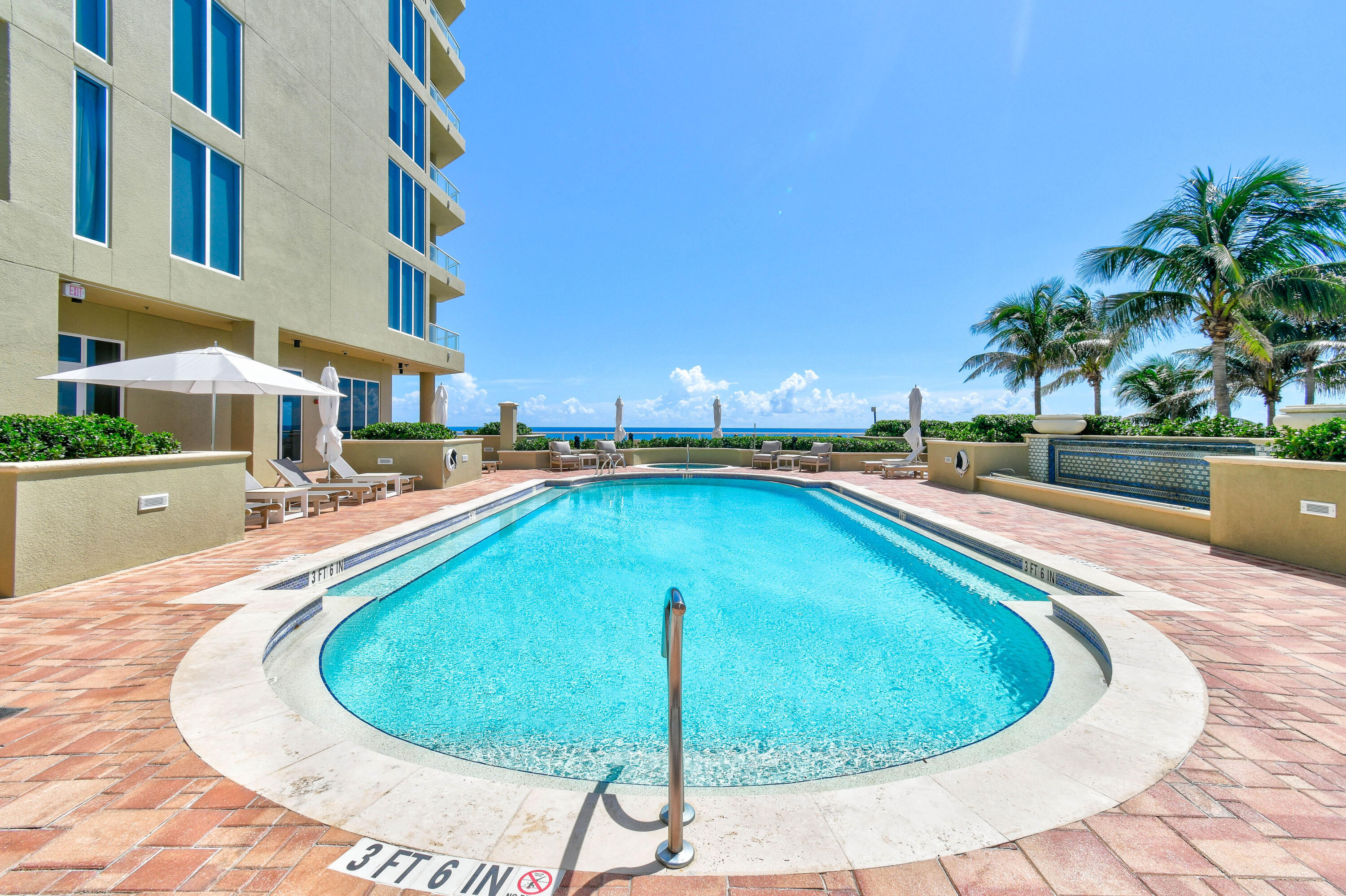 5050 North Ocean Drive, Unit 703 Singer Island, FL 33404 - Photo 38 of 52 a swimming pool with outdoor seating and yard