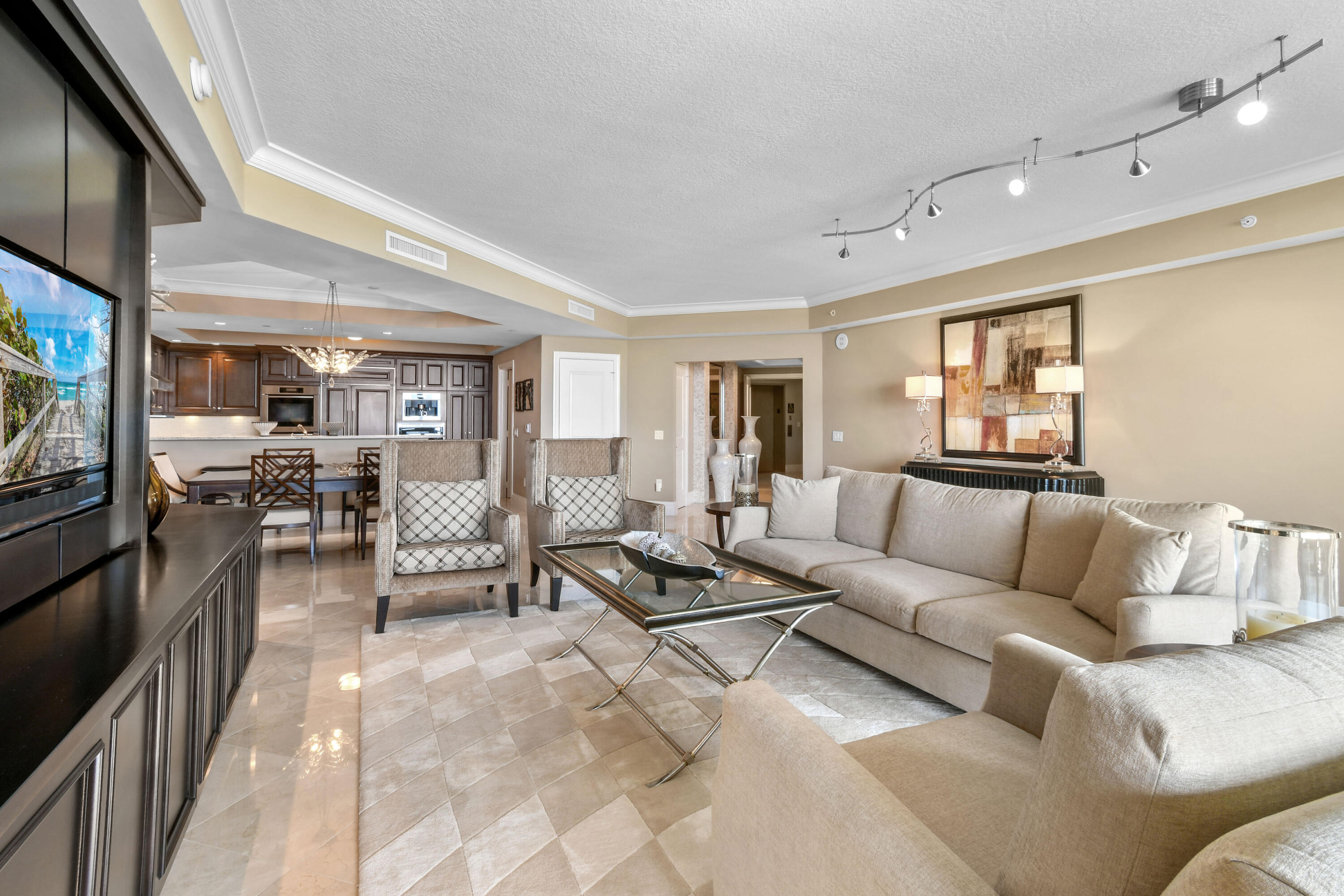 5050 North Ocean Drive, Unit 703 Singer Island, FL 33404 - Photo 4 of 52 a living room with furniture and a flat screen tv