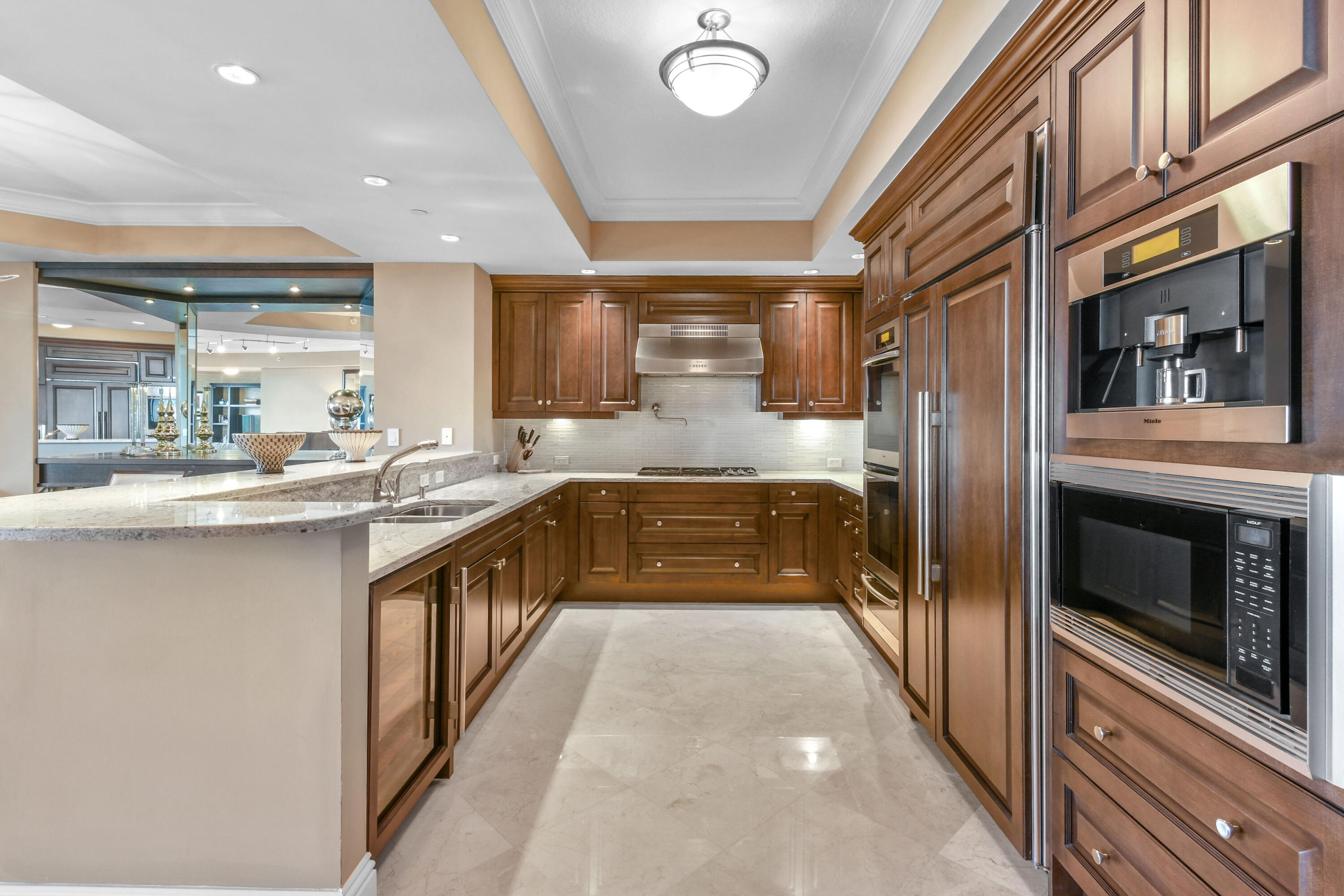 5050 North Ocean Drive, Unit 703 Singer Island, FL 33404 - Photo 8 of 52 a large kitchen with stainless steel appliances a large counter top a stove and a refrigerator
