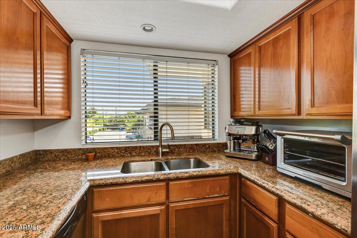 3235 East Camelback Road, Unit 218 Phoenix, AZ 85018 - Photo 14 of 23 a kitchen with granite countertop a sink and a window