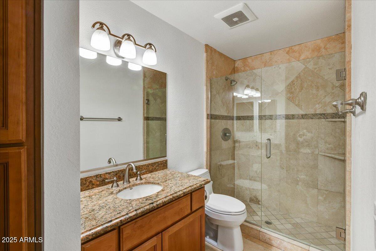 3235 East Camelback Road, Unit 218 Phoenix, AZ 85018 - Photo 16 of 23 a bathroom with a granite countertop sink toilet and shower