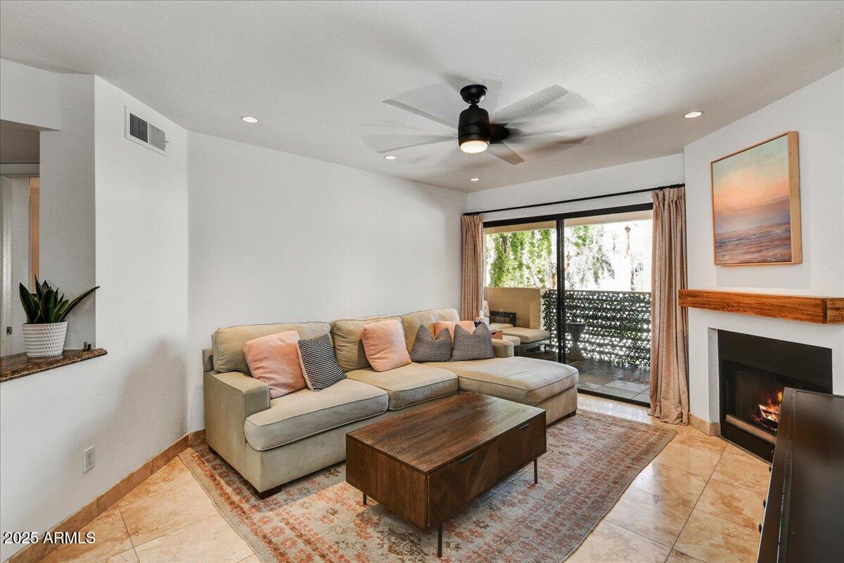 3235 East Camelback Road, Unit 218 Phoenix, AZ 85018 - Photo 5 of 23 a living room with furniture a flat screen tv and a fireplace