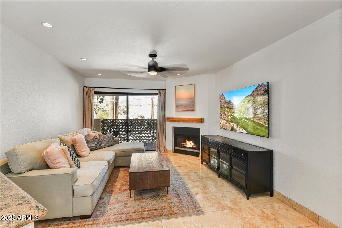 3235 East Camelback Road, Unit 218 Phoenix, AZ 85018 - Photo 6 of 23 a living room with furniture a fireplace and a flat screen tv