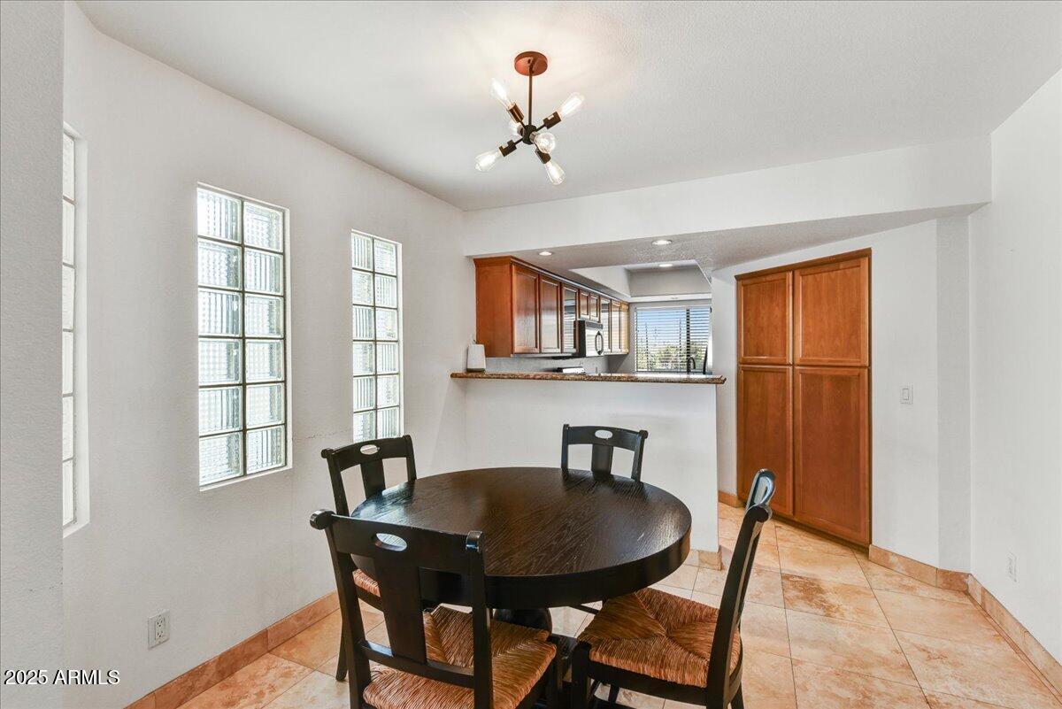 3235 East Camelback Road, Unit 218 Phoenix, AZ 85018 - Photo 9 of 23 a view of a dining room with furniture window and wooden floor