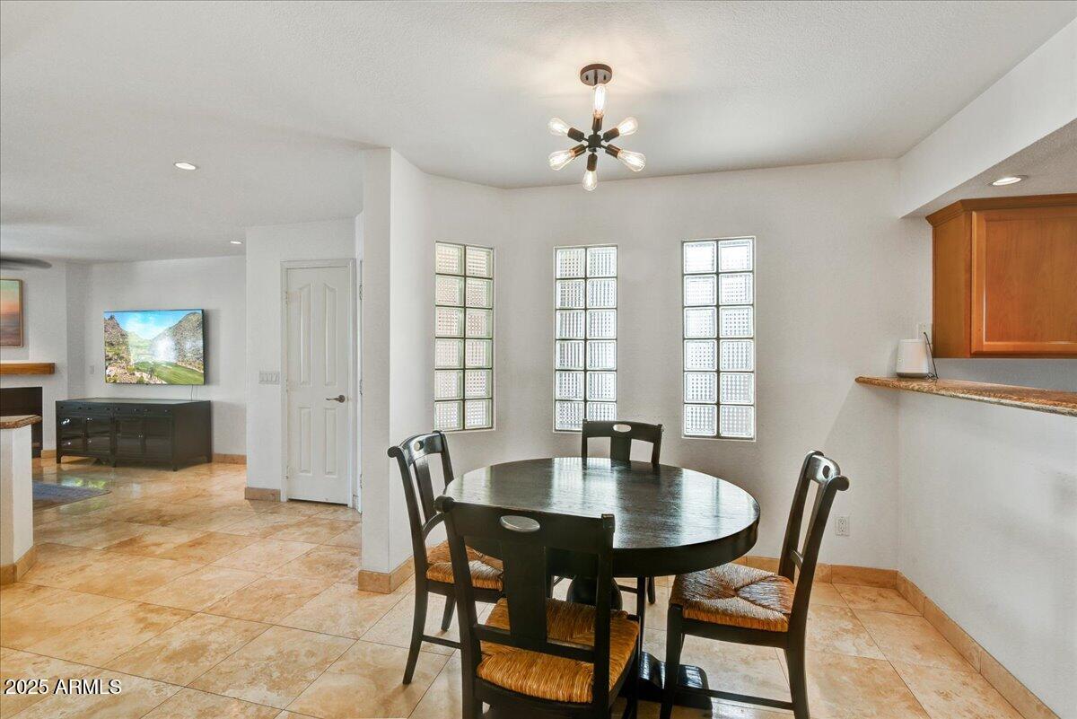 3235 East Camelback Road, Unit 218 Phoenix, AZ 85018 - Photo 10 of 23 a view of a dining room with furniture and chandelier