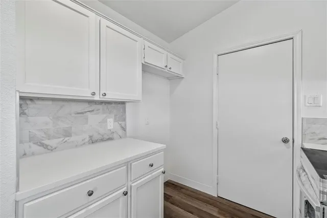 a view of cabinets and utility room with closet