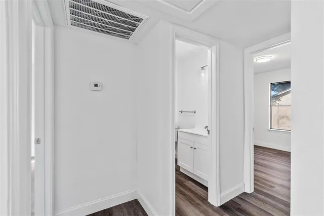 a view of a hallway with closet and wooden floor