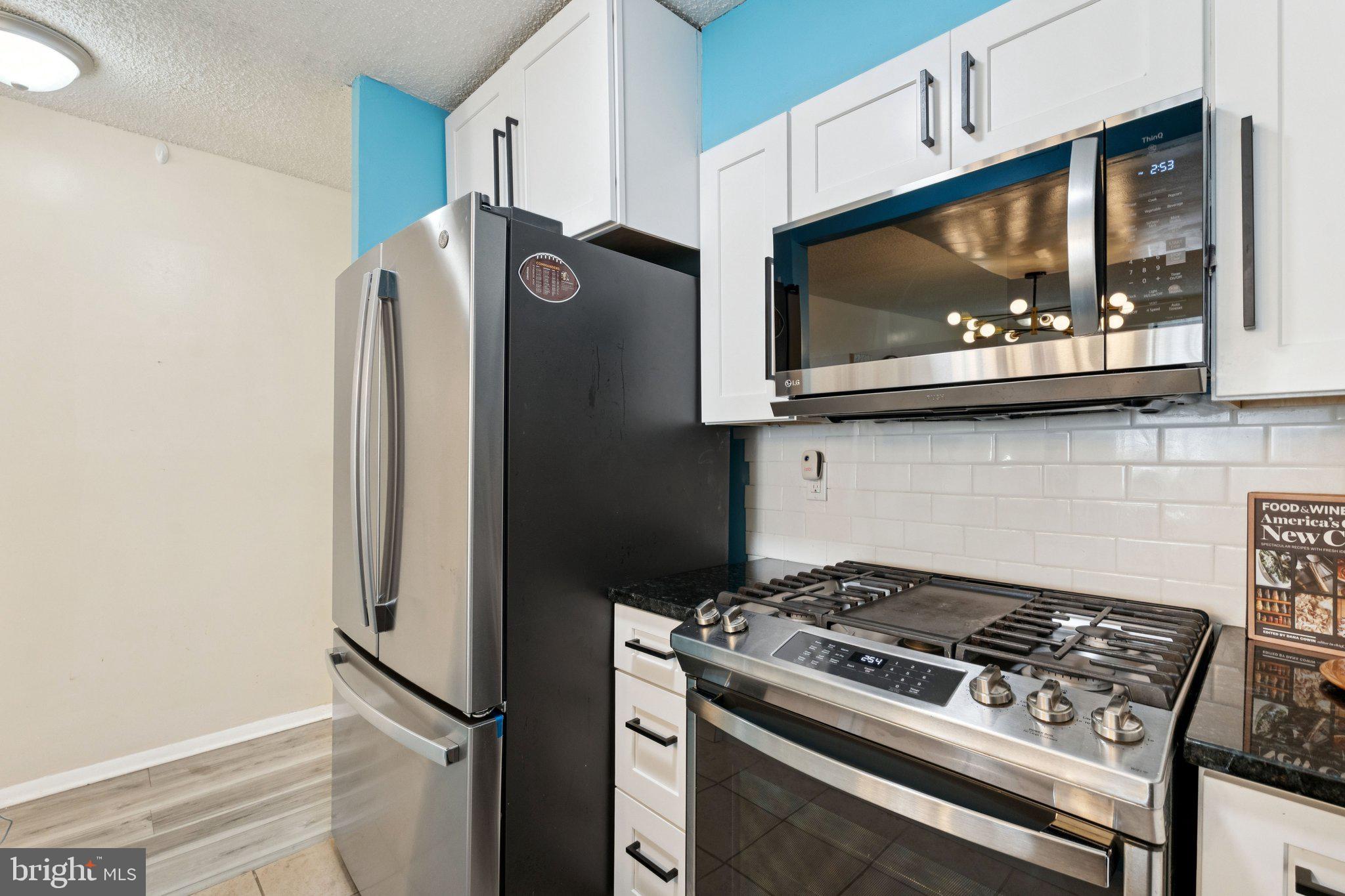 1245 13th Street Northwest, Unit 109 Washington, DC 20005 - Photo 11 of 25 a kitchen with stainless steel appliances white cabinets and a stove top oven