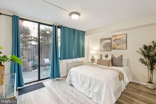 a bedroom with a large bed and a potted plant