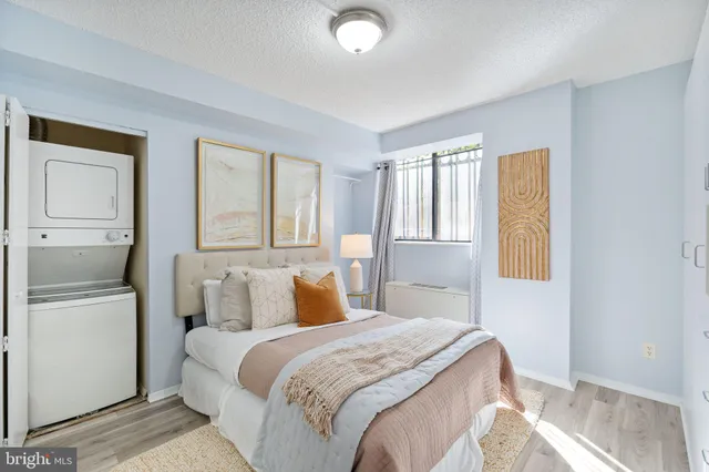 a bedroom with a bed and a refrigerator