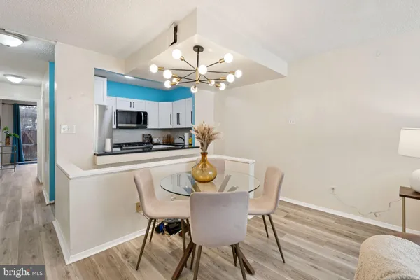 a view of a dining room with furniture a chandelier and wooden floor