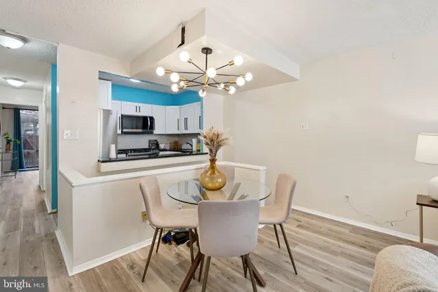 a view of a dining room with furniture a chandelier and wooden floor
