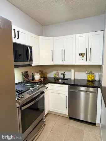 a kitchen with stainless steel appliances granite countertop a stove and a refrigerator