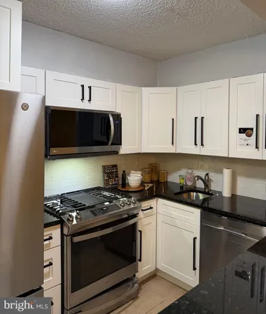 a kitchen with stainless steel appliances a stove a microwave a sink and cabinets