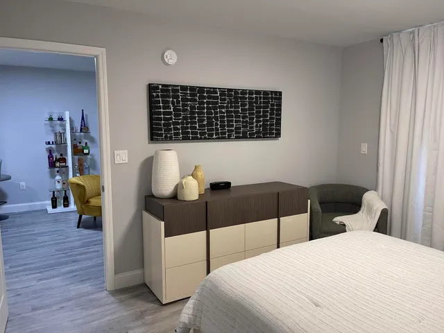 a bedroom with a bed and a lamp on dresser