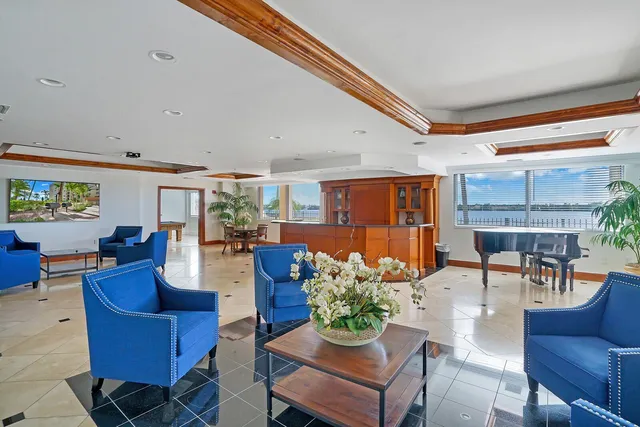 a living room with furniture kitchen view and a large window