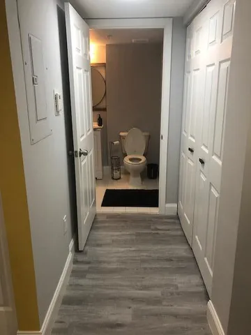 a view of a hallway with wooden floor and staircase