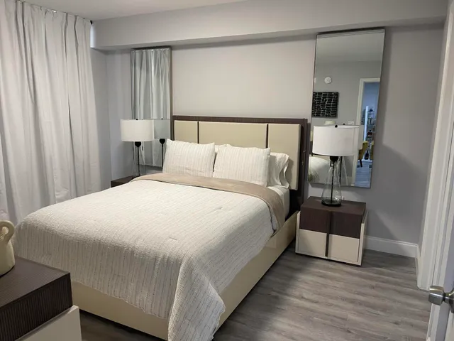 a large bed sitting in a bedroom next to a window and a chair