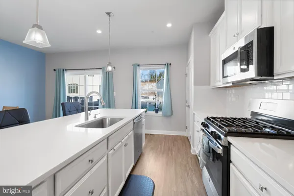 a kitchen with stainless steel appliances granite countertop a sink stove and microwave