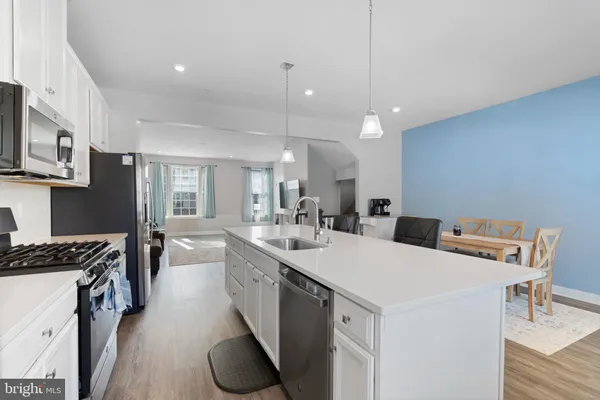 a kitchen that has a sink a stove and chairs