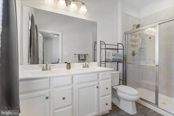 a bathroom with a sink toilet vanity and shower