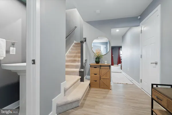a view of a hallway with wooden floor and staircase