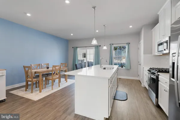 a large kitchen with kitchen island a dining table and chairs
