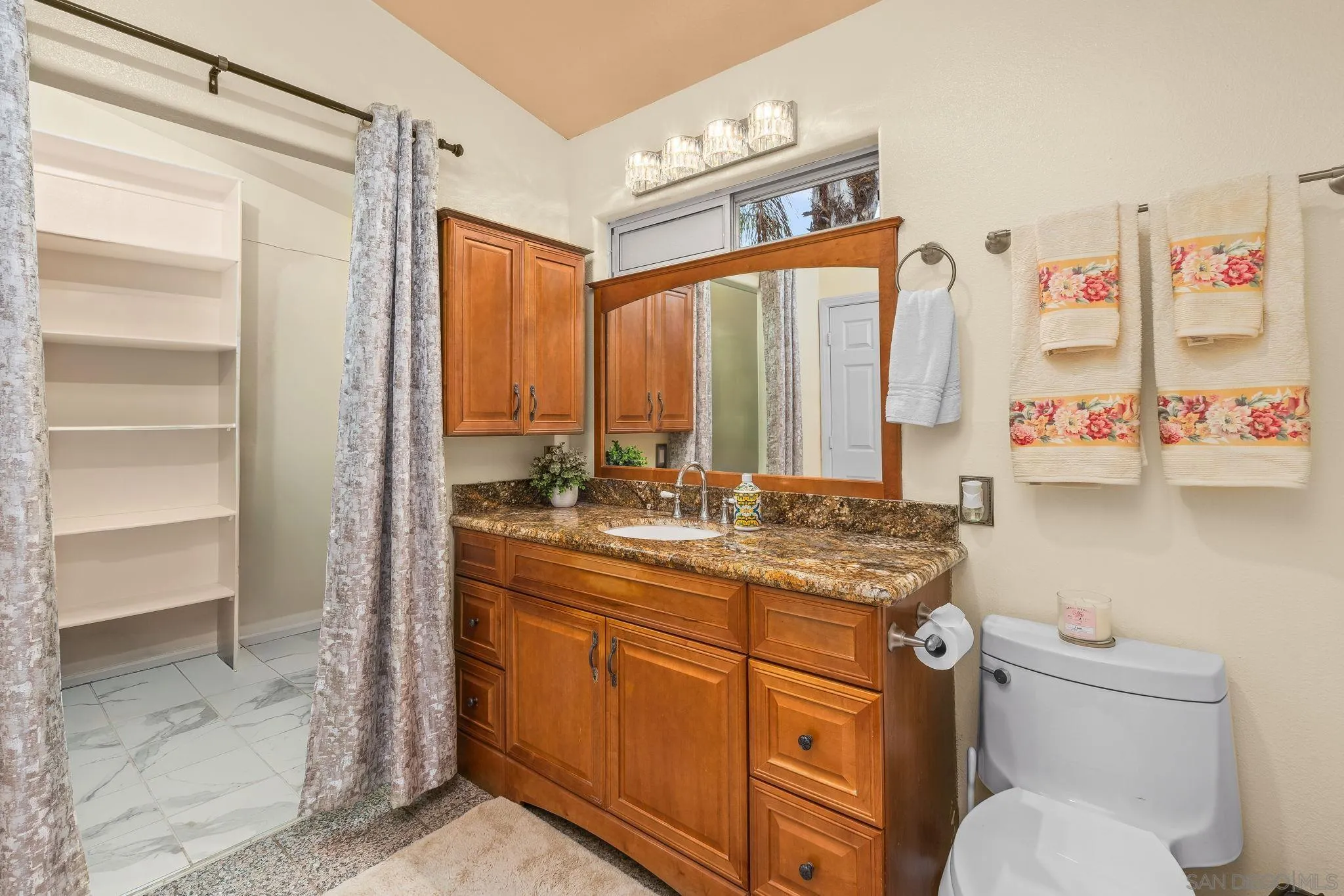 1451 Vía Lima Fallbrook, CA 92028 - Photo 18 of 41 a bathroom with a granite countertop sink a toilet and a large mirror
