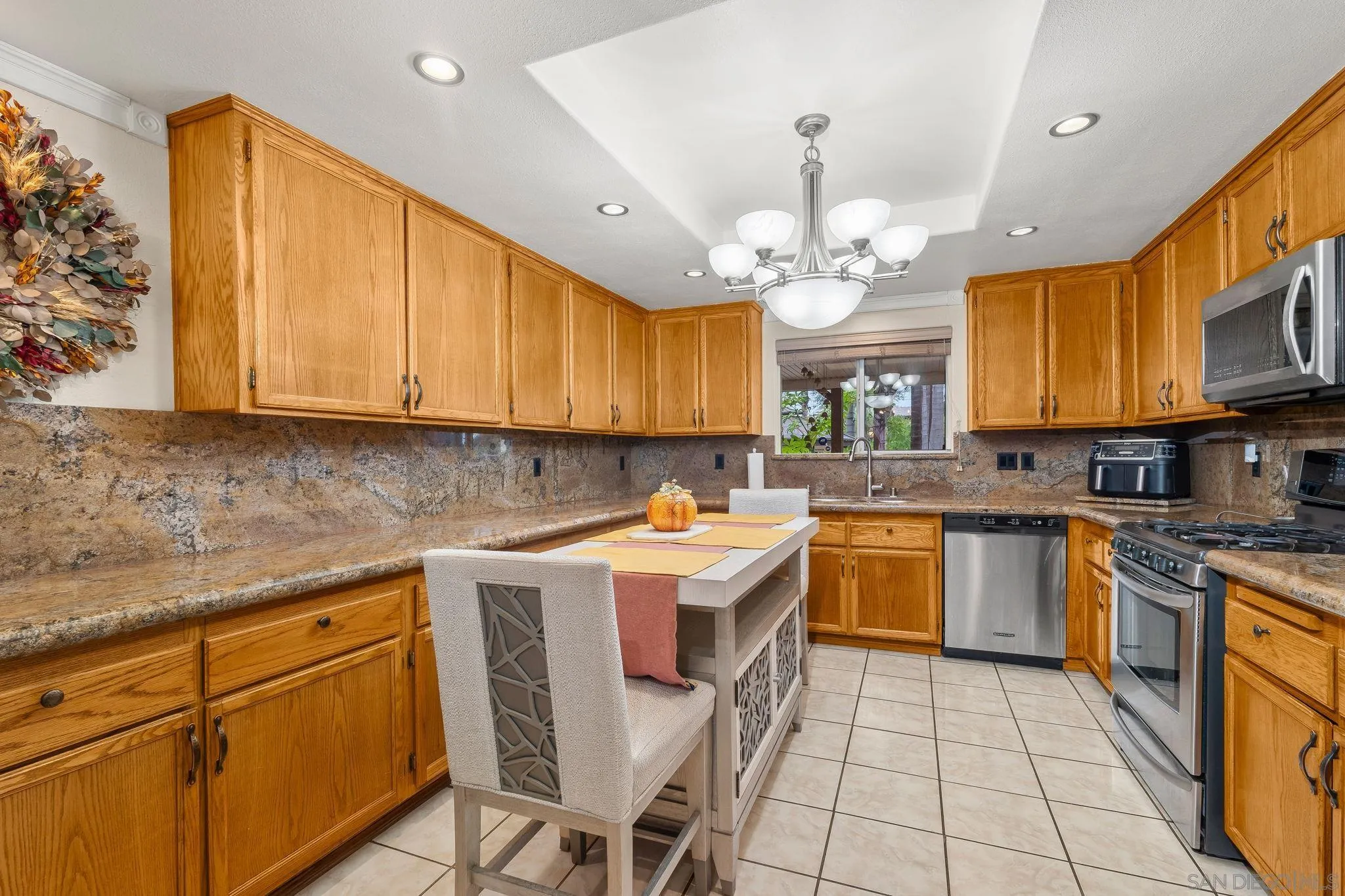 1451 Vía Lima Fallbrook, CA 92028 - Photo 29 of 41 a kitchen with a stove window cabinets dining table and chairs