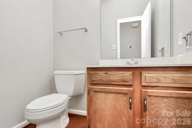 a bathroom with a granite countertop toilet sink and mirror