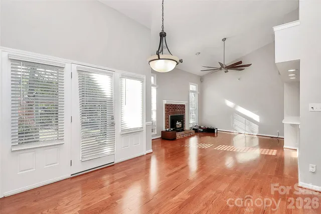a view of empty room with wooden floor and fireplace