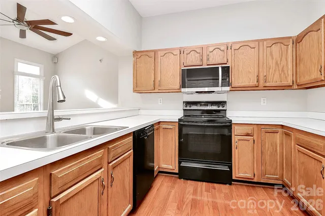 a kitchen with granite countertop a sink stainless steel appliances and cabinets