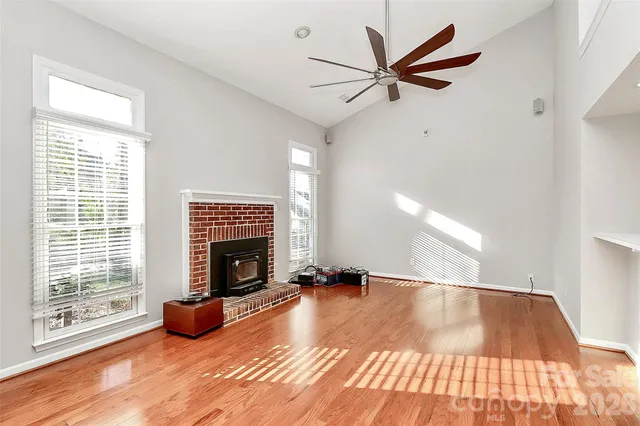 a view of an empty room with window and fire place
