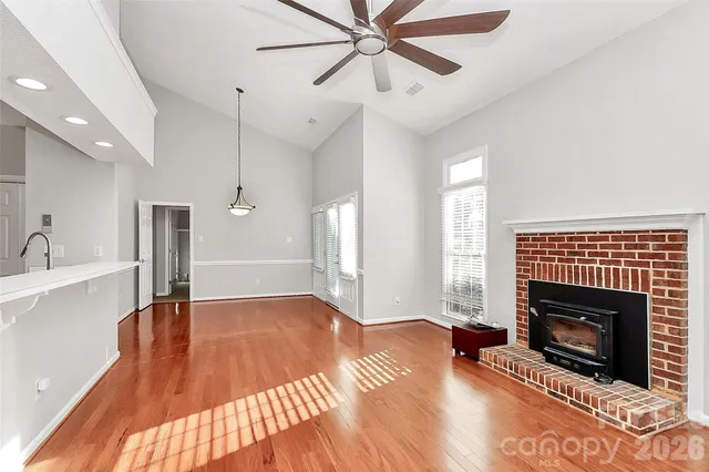 a view of empty room with wooden floor and a fireplace
