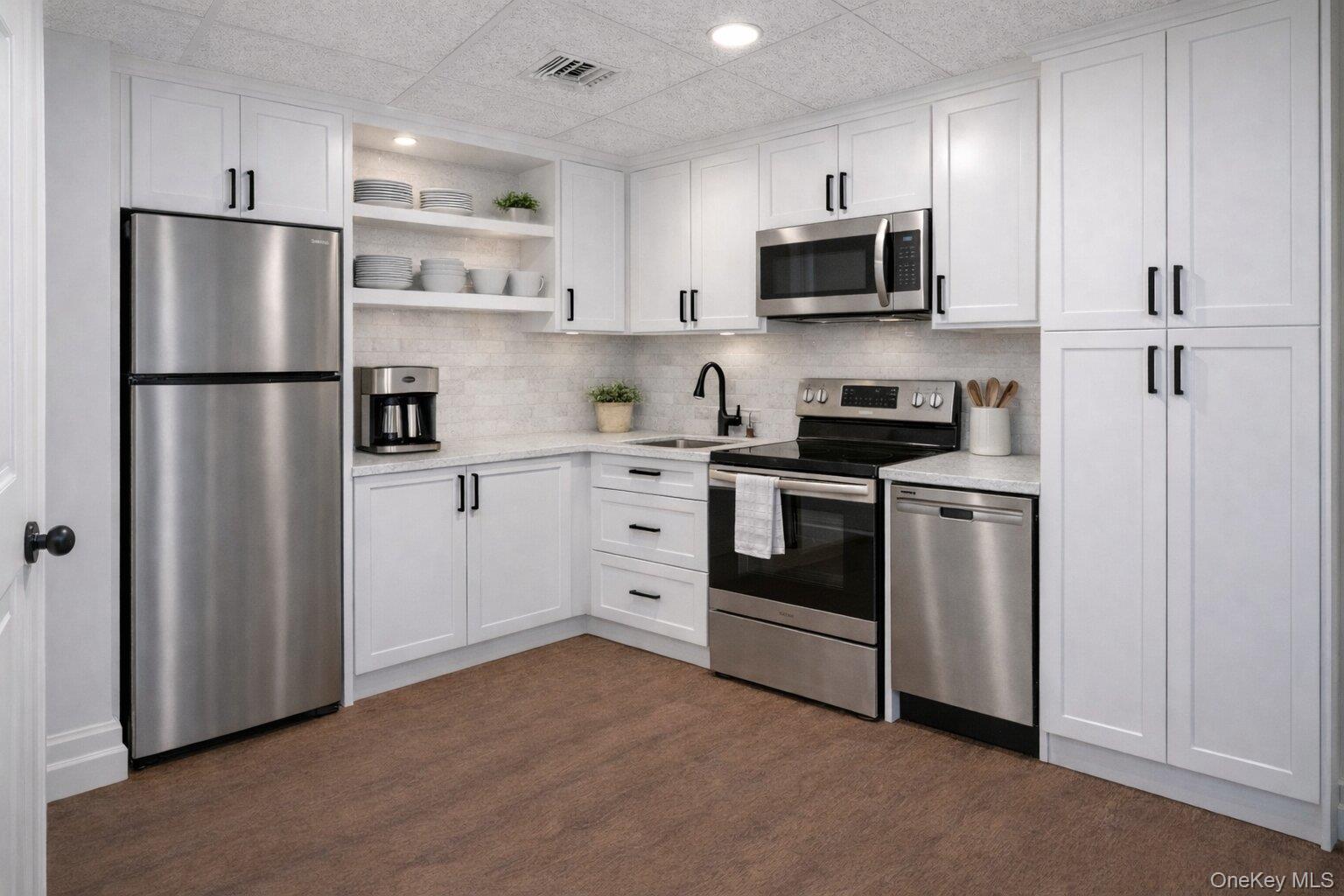 22 Delaware Avenue Jericho, NY 11753 - Photo 18 of 35 a kitchen with stainless steel appliances white cabinets white refrigerator and microwave