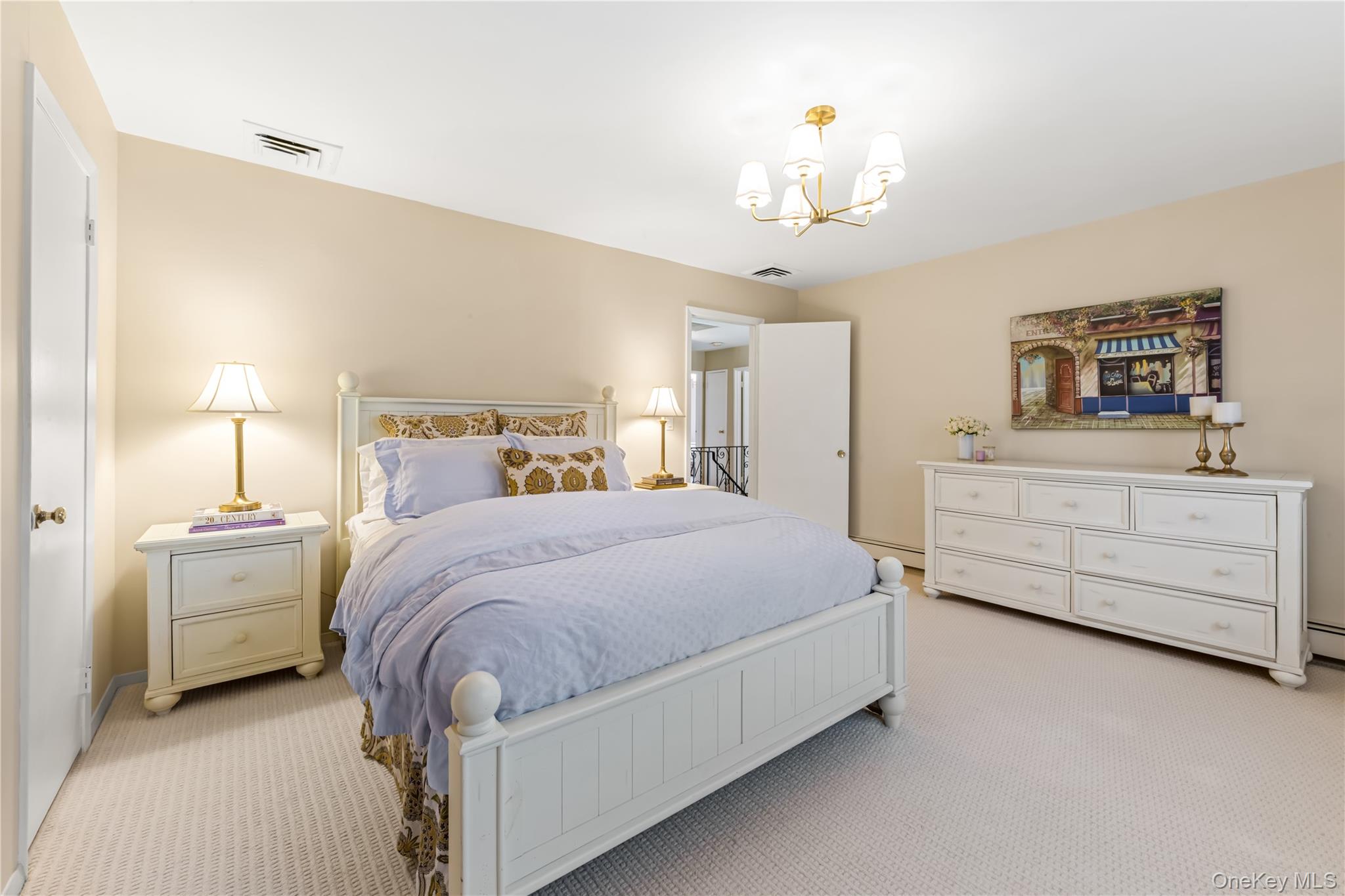 22 Delaware Avenue Jericho, NY 11753 - Photo 22 of 35 a spacious bedroom with a bed a chandelier and a dresser in it