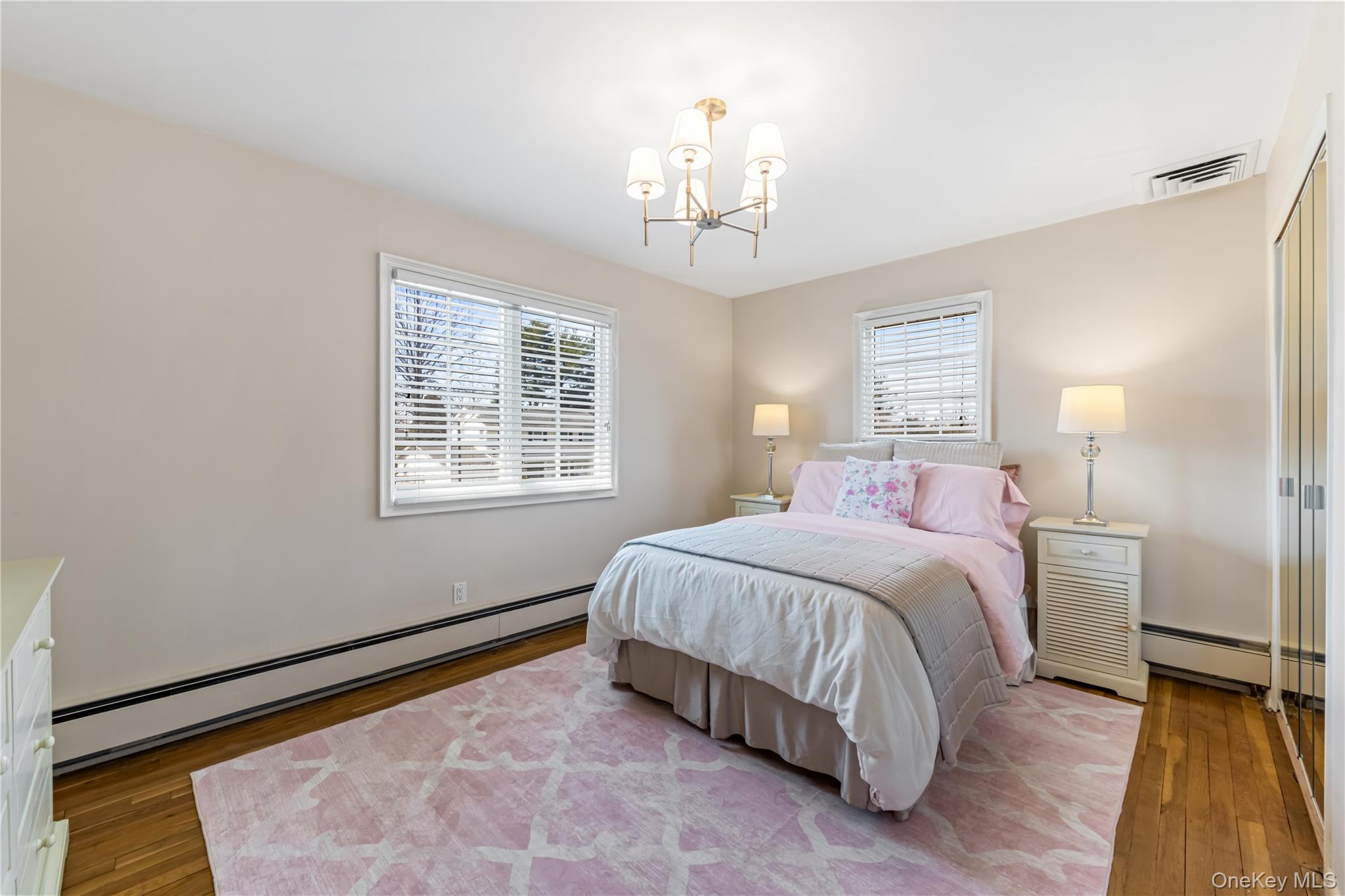 22 Delaware Avenue Jericho, NY 11753 - Photo 28 of 35 a bedroom with a bed and a chandelier