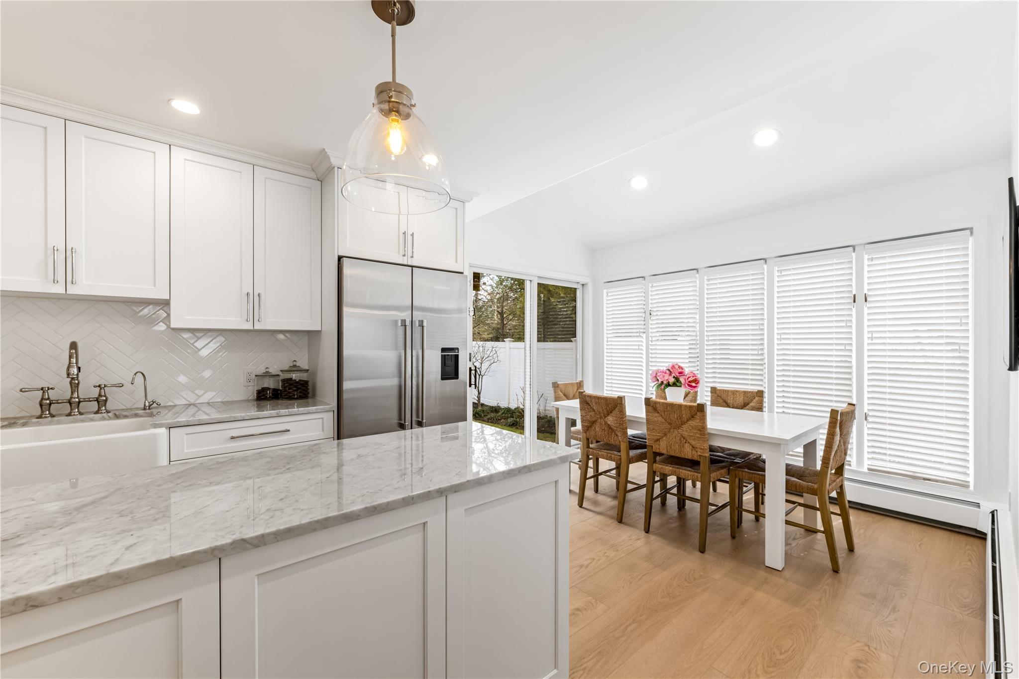 22 Delaware Avenue Jericho, NY 11753 - Photo 6 of 35 a kitchen with granite countertop a dining table chairs and white cabinets