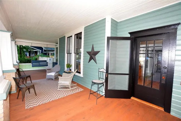 a view of a white house with a big yard and large tree